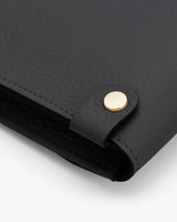 Close-up of a handbag corner with a metallic clasp.
