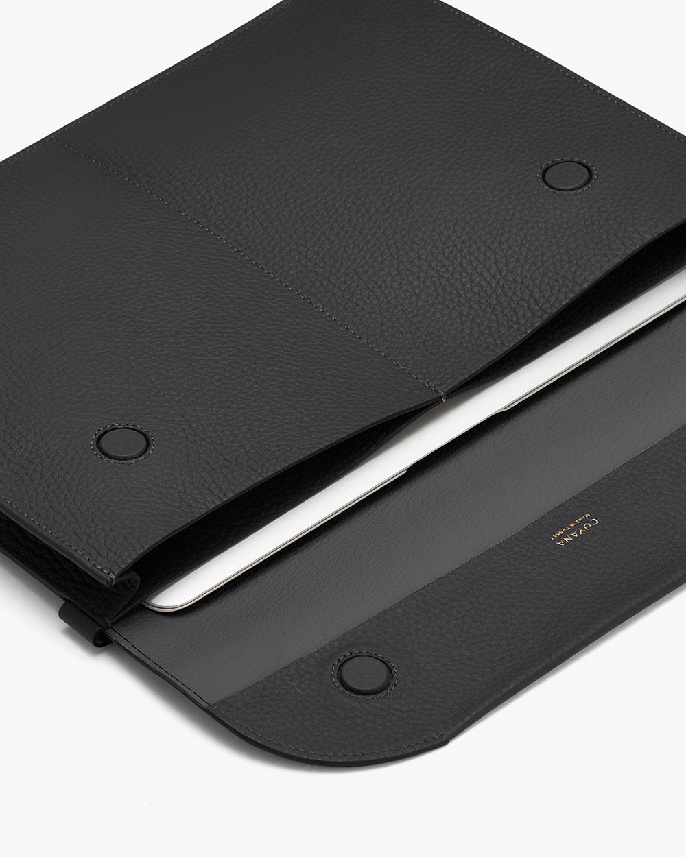 Closed leather folio with a laptop partially visible inside.
