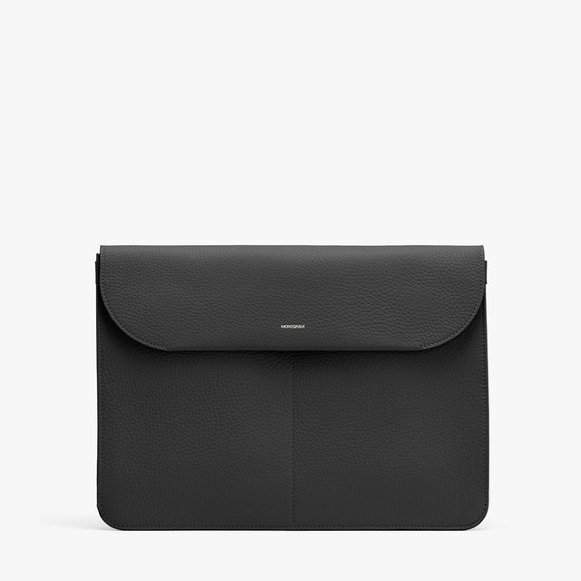 Leather laptop bag with front flap and minimal branding.