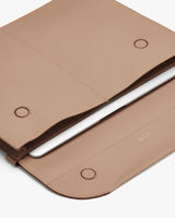 Laptop in an open sleeve on a flat surface.