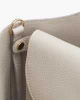 Close-up of a handbag showing its texture and metal hardware details.