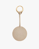 Round keychain with a textured surface and a loop attached to a ring.