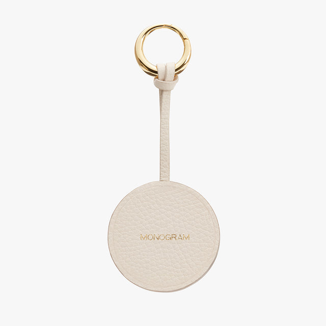 Keyring with a circular tag labeled MONOGRAM and a metal ring attached by a strap.