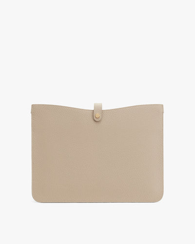 Leather pouch with a flap and button closure on a plain background.