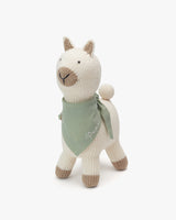 Stuffed alpaca wearing a bandana standing upright.