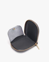 Open small round wallet with zipper on a solid background.