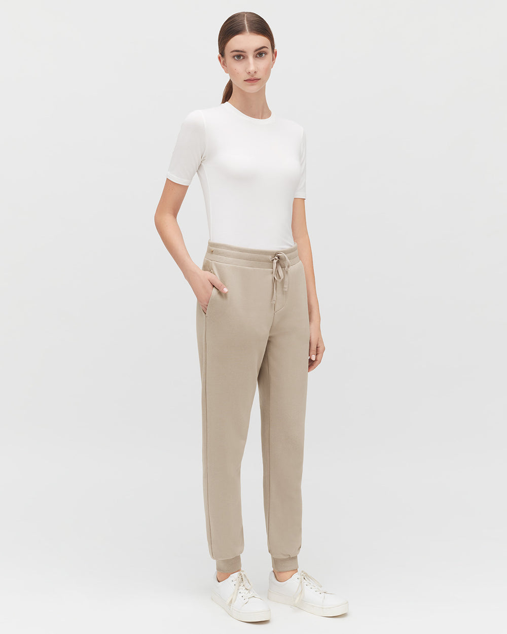 Fleece Jogger Pant Woman standing in a short-sleeved top and drawstring pants.