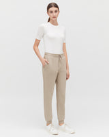 Woman standing in a short-sleeved top and drawstring pants.