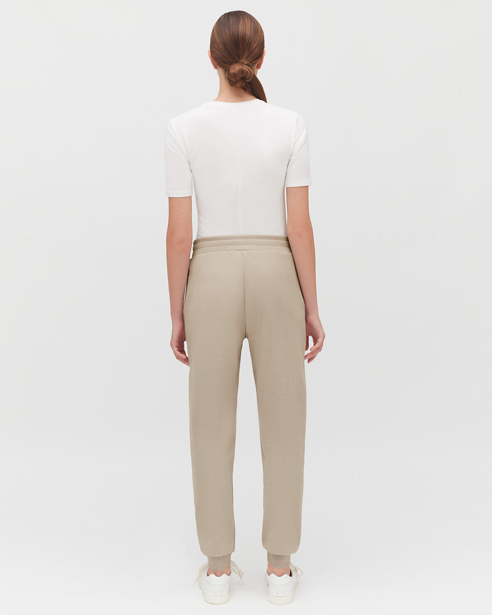 Fleece Jogger Pant Woman standing with her back to the camera, wearing a top and pants.