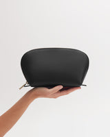 A hand holding a small zippered pouch.