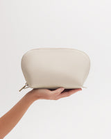 Hand holding a small pouch with a zipper