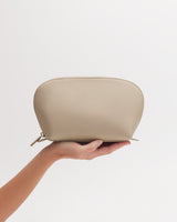 Hand holding a small pouch with a zipper