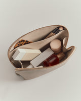 Open cosmetic bag with various beauty products inside.