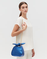 Woman standing with a handbag over her shoulder