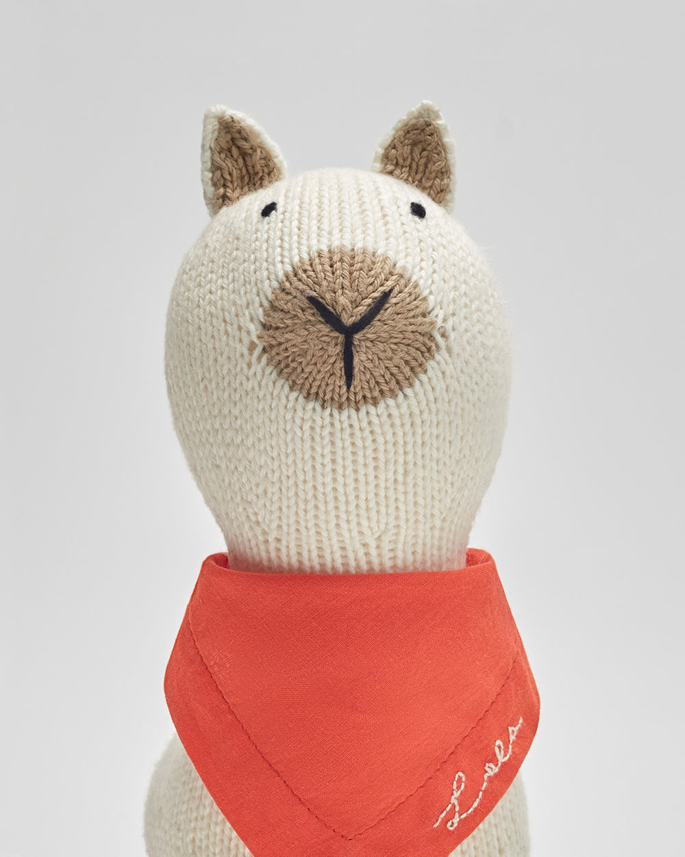 Stuffed alpaca with a scarf around its neck