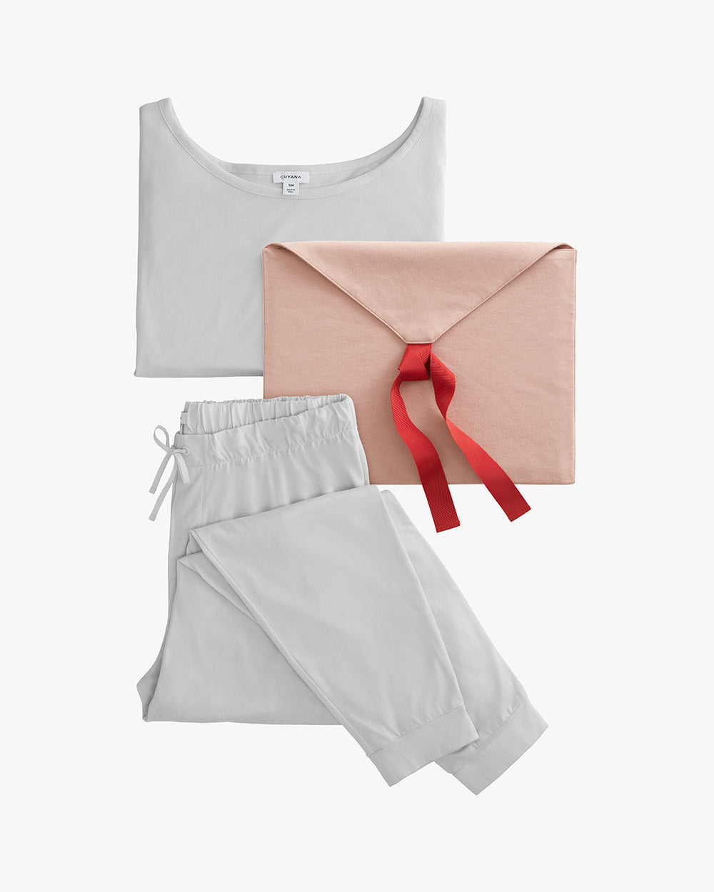 Top, trousers, and clutch with a bow placed together.