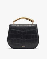 Handbag with a curved top handle and textured exterior.