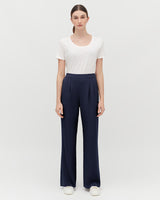 Woman standing in a t-shirt and trousers with hands at her sides