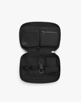 Open travel case displaying organized compartments and accessories.