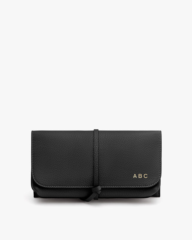 Wallet with a strap closure and monogram initials 'ABC' on front.
