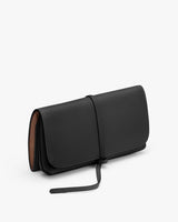 Closed clutch bag with a loop closure on a plain background.