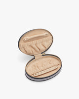 Open round case with a textured interior and a zip closure.