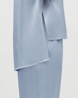 Person wearing a shirt and skirt outfit.