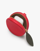 Round pouch with zipper and leaf-shaped pull tab, containing a small white case.
