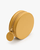 Round textured leather pouch with zipper and circular pull tab.