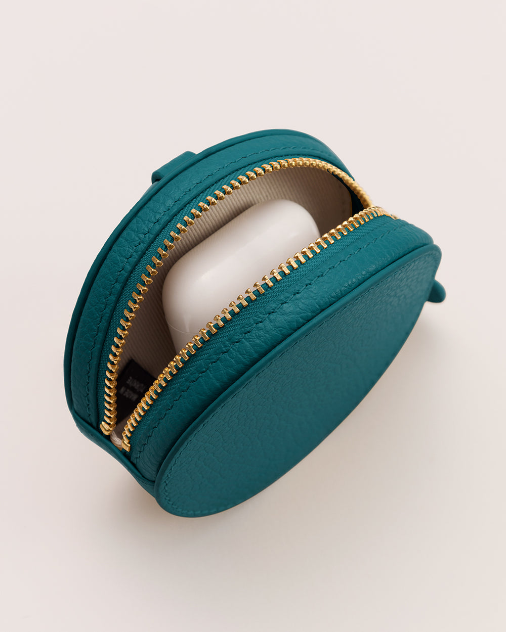 Round case with zipper partially open, showing contents inside.