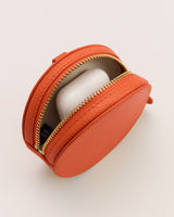 Small round leather zip case with item inside.