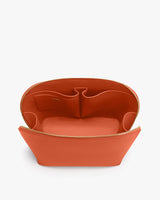 Open handbag with multiple interior compartments and a zipper closure.