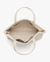 Open handbag viewed from top showing interior and handles.