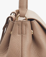 Close-up view of a handbag focusing on the handle and stitching details.