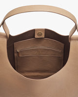 Open handbag showing interior with a zip pocket and a buttoned strap.