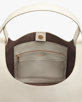 Open handbag showing internal pocket and zip compartment.