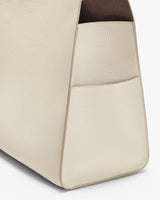 Close-up view of a textured handbag with a visible pocket.