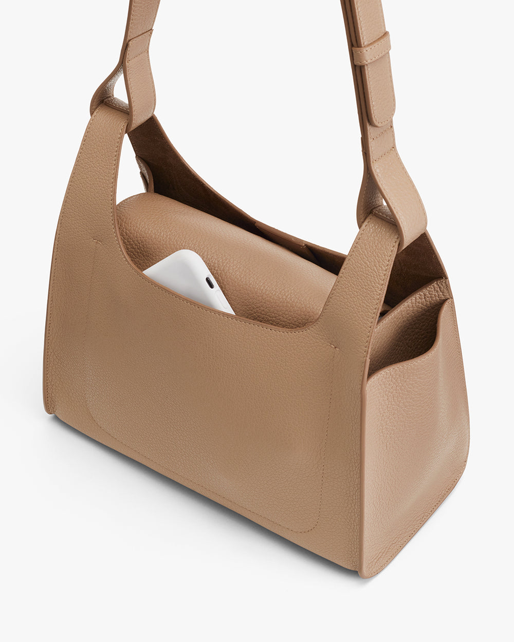 Handbag with a laptop inside on a plain background.