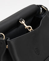 Close-up of an open handbag with a metallic clasp.