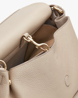 Open handbag with a visible interior and a metal chain attachment.