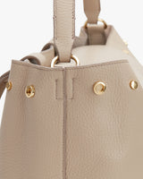 Close-up of a handbag with metallic details and stitching.
