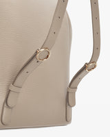 Close-up of a bag with adjustable straps and metal rings.