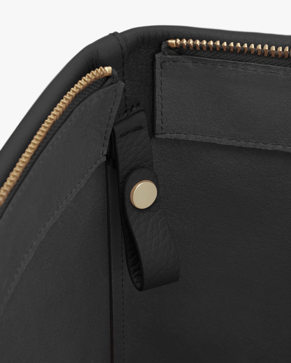 Open handbag with gold zipper and interior compartment.