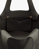 Close-up of an open handbag with a visible brand name on the inner pocket.