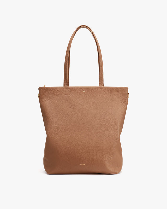 Leather tote bag with two handles and a zipper closure.