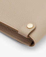 Close-up of a handbag corner with metal clasp.