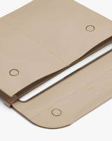Laptop in a textured sleeve with flap closure.