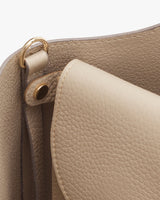Close-up of a handbag with a focus on the handle attachment.