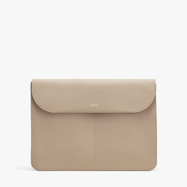 Laptop sleeve with front flap on plain background.