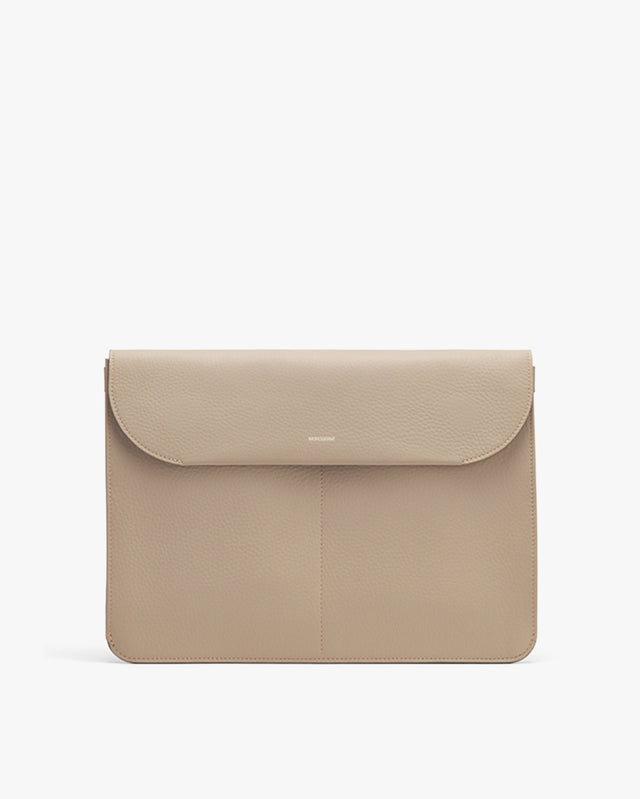 Laptop sleeve with front flap on plain background.
